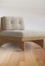 Modern wooden lounge chair with beige cushions, handcrafted from solid wood with a minimalist Scandinavian design.