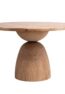 NOMA solid teak round dining table handcrafted in Jepara featuring a sculptural pedestal base and modern organic design.